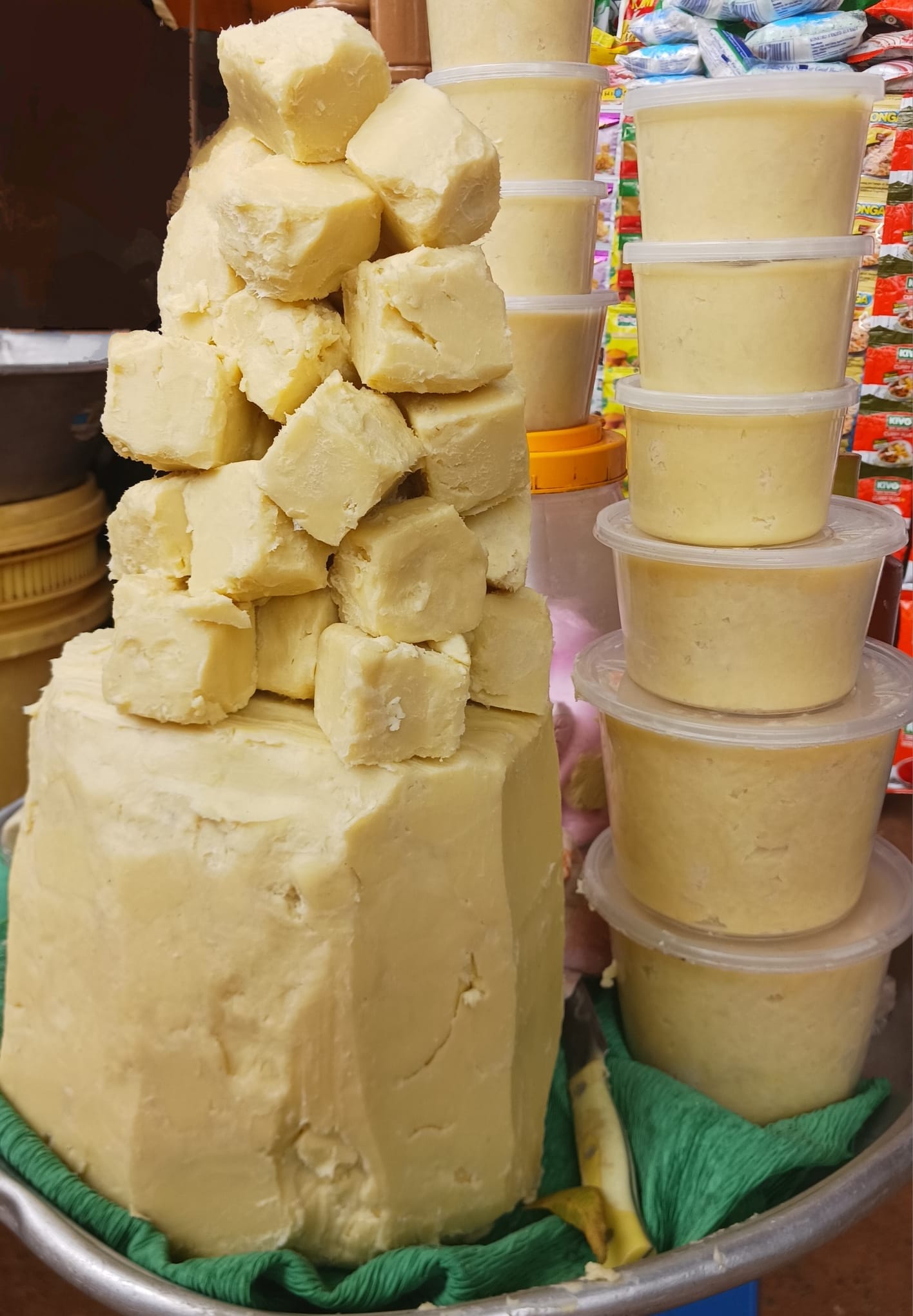 Picture of organic shea butter in raw form along with packaged shea butter next to it, on the right.